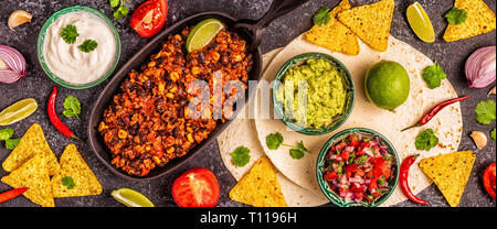 Mexican food concept: tortillas, nachos with guacamole, salsa, chili con carne, top view. Stock Photo