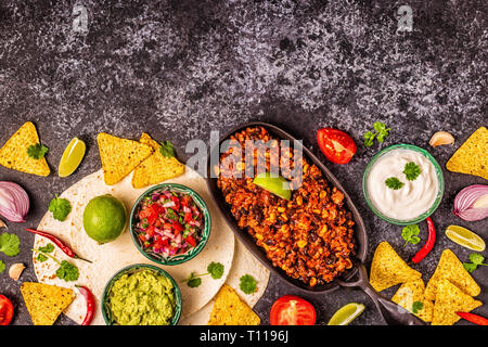 Mexican food concept: tortillas, nachos with guacamole, salsa, chili con carne, top view. Stock Photo