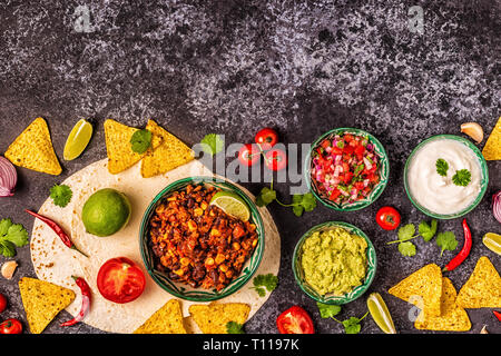Mexican food concept: tortillas, nachos with guacamole, salsa, chili con carne, top view. Stock Photo