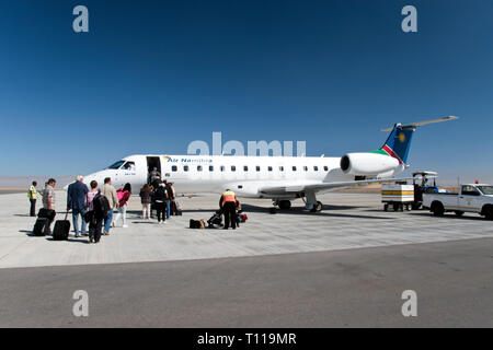 Passengers board an Air Namibia Embraer ERJ 135 regional jet at the Walvis Bay Airport, Namibia. Stock Photo