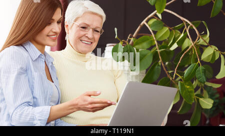 Daughter teaching her senior mother using laptop Stock Photo