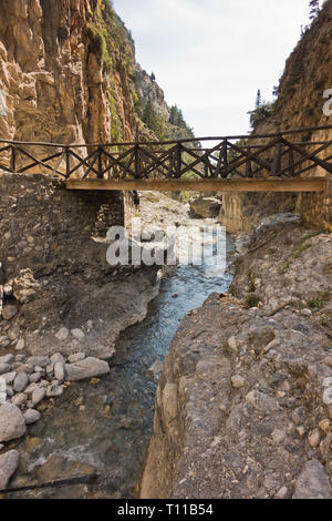 Wooden bridge over mountain river at rocky terrain of Samaria gorge, south west part of Crete island, Greece Stock Photo