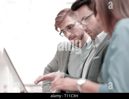 close up.three employees using a laptop. Stock Photo