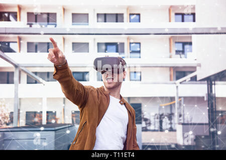 Cheerfully Young Adult Charming Man Using VR Virtual Reality Glasses with Draw Background Stock Photo
