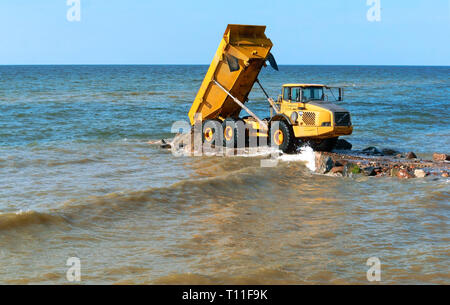 construction of breakwaters, construction equipment on the sea coast, Baltic sea, Kaliningrad region, Russia, July 22, 2018 Stock Photo