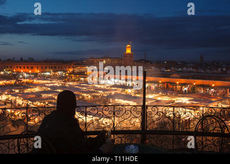Marrakesh at night showing illuminated minaret tower and numerous large market  stalls Stock Photo