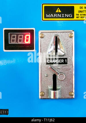 Close-up of a rather self-made mobile phone battery charging station on a ship in the Philippines. Coins have to be inserted to operate the charging. Stock Photo