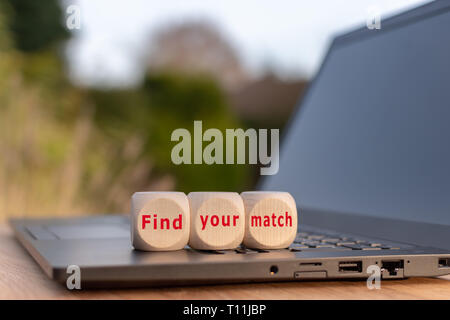 Cubes placed on a notebook form the expression 'find your match'. Stock Photo