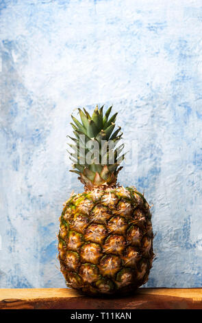 Whole pineapple fruit against a blue background Stock Photo