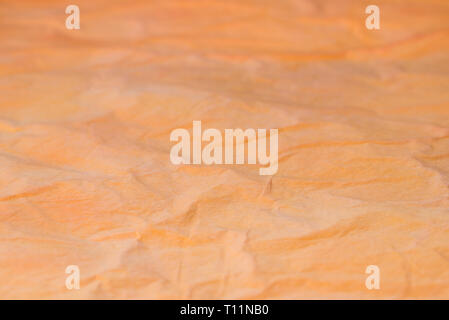 orange color creased tissue papet background texture selective focus macro Stock Photo
