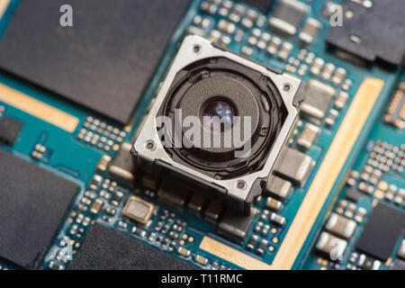 Mobile phone camera module on a blue printed circuit board. Stock Photo