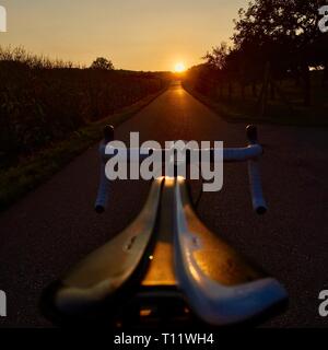 looking over the saddle of a road bike towards sunset Stock Photo