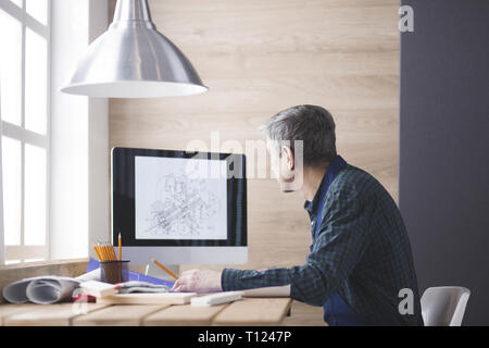 Engineer carpenter working on laptop and sketching project Stock Photo