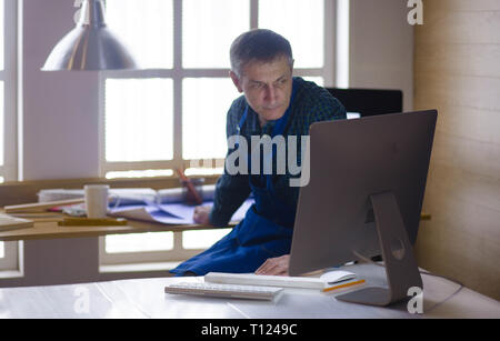 Engineer carpenter working on laptop and sketching project Stock Photo