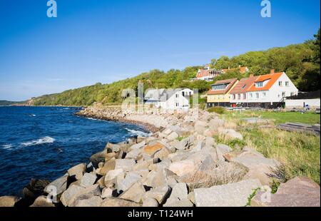 View of fishing hamlet on west coast of Bornholm island, Vang, Denmark. Ruins of Hammershus castle in the background. Stock Photo