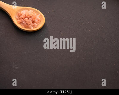 Wooden spoon with Himalayan pink salt on a slate plate Stock Photo