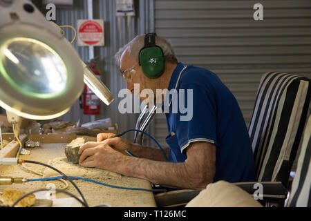 Volunteers extract the bones from rock at the dinosaur bone preparation lab at The Australian Age Of Dinosaurs, Winton, Queensland. Stock Photo