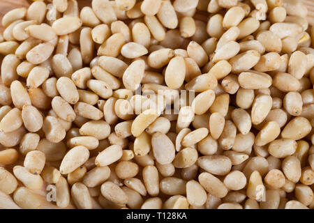 Close up of pine nuts scattered on wooden surface Stock Photo