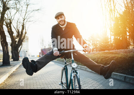 Smiling hipster man with bicycle having fun Stock Photo