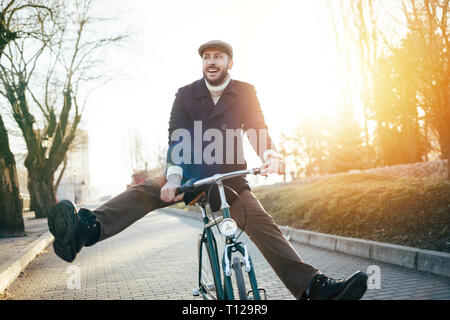 Smiling hipster man with bicycle having fun Stock Photo