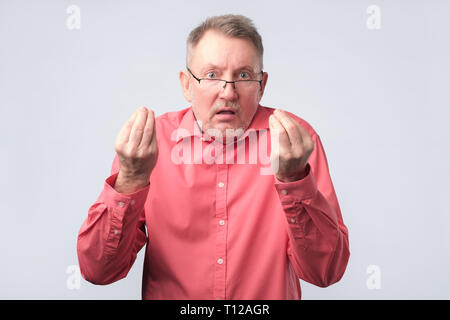 Senior man looking angry showing italian gesture. Stock Photo