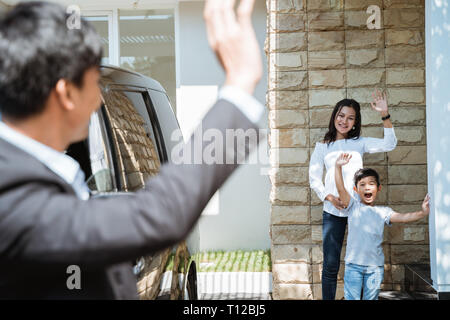 father waving goodbye to his family before going to work Stock Photo