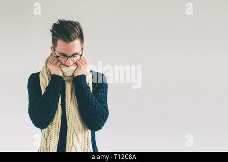 Young man in sweater feel cold over a white background Stock Photo