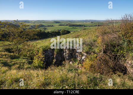 Eldon Hole, a deep chasm in the limestone landscape near Peak Forest in the Peak District, Derbyshire, England. Stock Photo