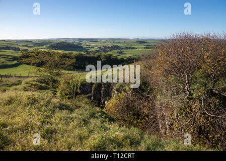 Eldon Hole, a deep chasm in the limestone landscape near Peak Forest in the Peak District, Derbyshire, England. Stock Photo