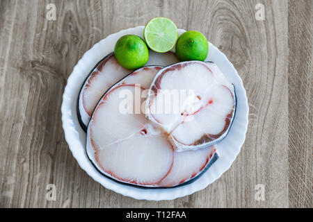 raw blue shark meat and lime on white plate Stock Photo