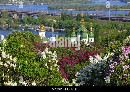 Spring view of Vydubychi Monastery and Dnipro river with pink and white lilac blossoming in the botanical garden in Kyiv city, Ukraine. Iconic picture Stock Photo