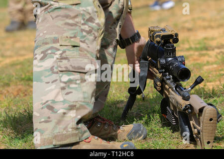 A competitor in the United States Army Special Operations Command International Sniper Competition grabs his sniper rifle during a live-fire range event on Fort Bragg, North Carolina, March 19, 2019. Twenty-one teams competed in the USASOC International Sniper Competition where instructors from the United States Army John F. Kennedy Special Warfare Center and School designed a series of events that challenged the two-person teams’ ability to work together, firing range, speed and accuracy in varied types of environments. (U.S. Army photo by Sgt. Michelle Blesam) Stock Photo