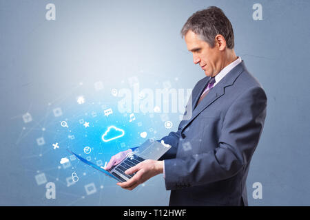 Man holding laptop projecting notifications, symbols and information based on cloud technology system  Stock Photo