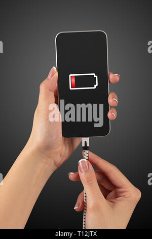 Elegant hand charging cellphone with low battery  Stock Photo