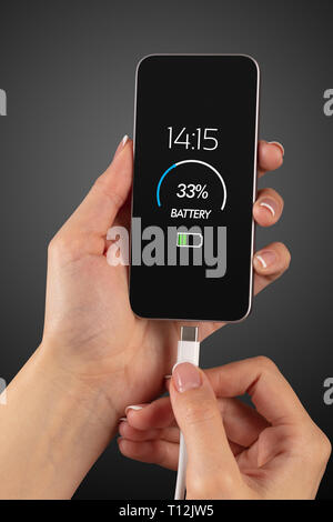 Elegant hand charging cellphone with low battery  Stock Photo