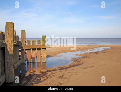 End of a wooden breakwater with drainage to the sea at low tide on the North Norfolk coast at Bacton-on-Sea, Norfolk, England, United Kingdom, Europe. Stock Photo