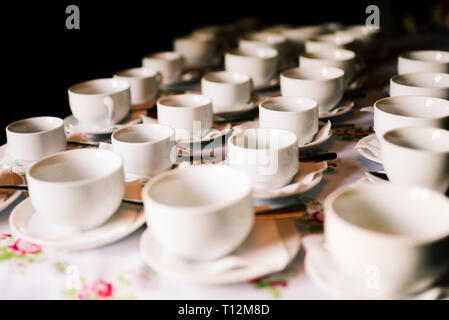 White cups on the table. Many empty cups stand in a row on the table. Preparing for the banquet Stock Photo
