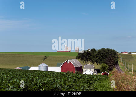 Farm fields with a red barn, grain silos, and a country road in Wisconsin, not far from the city of Oshkosh. Stock Photo