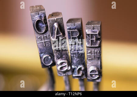 Macrophotography of typewriter hammers with CARE word Stock Photo