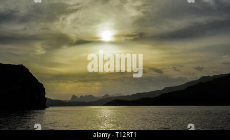 Sun on the background of mountains and the sea. Fjords of the Musandam Peninsula. Khasab bay. Oman Stock Photo