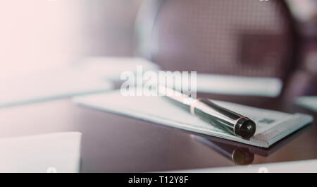 A pen on a check-book and papers all around. Stock Photo
