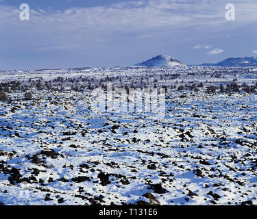 USA, California, Lava Beds National Monument, Snow covered lava flows and distant Schonchin Butte. Stock Photo