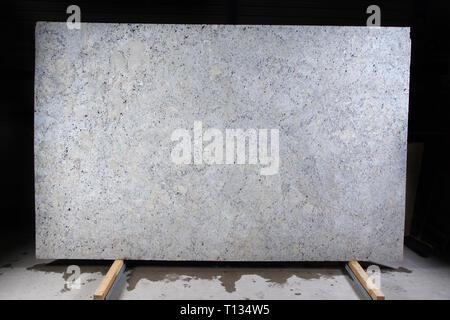 Natural stone of white color with dark specks, called granite Fantastic White. Stock Photo
