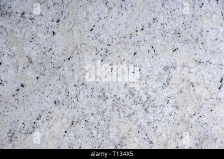 Background natural white stone with black dots, called granite Fantastic White. Stock Photo