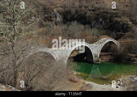The old historical and traditional stone three arch bridge of Plakida or Kalogeriko near Kipoi Greek village of Zagori in Ioannina, Epirus, Greece Stock Photo