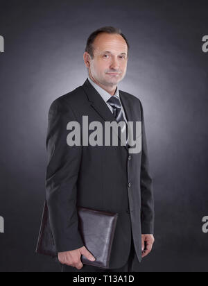 handsome businessman with a leather folder .isolated on black Stock Photo
