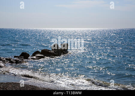 Blue Mediterranean sea with the sparkling surface and stones in Cyprus. Stock Photo
