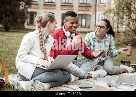 Positive delighted young people talking about studying Stock Photo