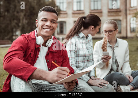 Attractive dark-skinned man feeling happiness while studying Stock Photo