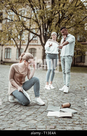 Two international students laughing at their friend Stock Photo